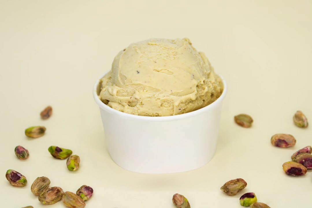 Taça de gelado de pistácio com frutos secos à volta